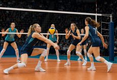 Волейболістка приймає силову подачу перед атакою команди